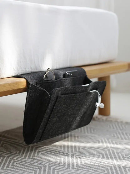 AmoorCity Felt Bedside Caddy. Felt bedside organizer with 5 pockets for storing phones, books, glasses, and other bedside essentials. Keeps items within reach while you relax in bed.